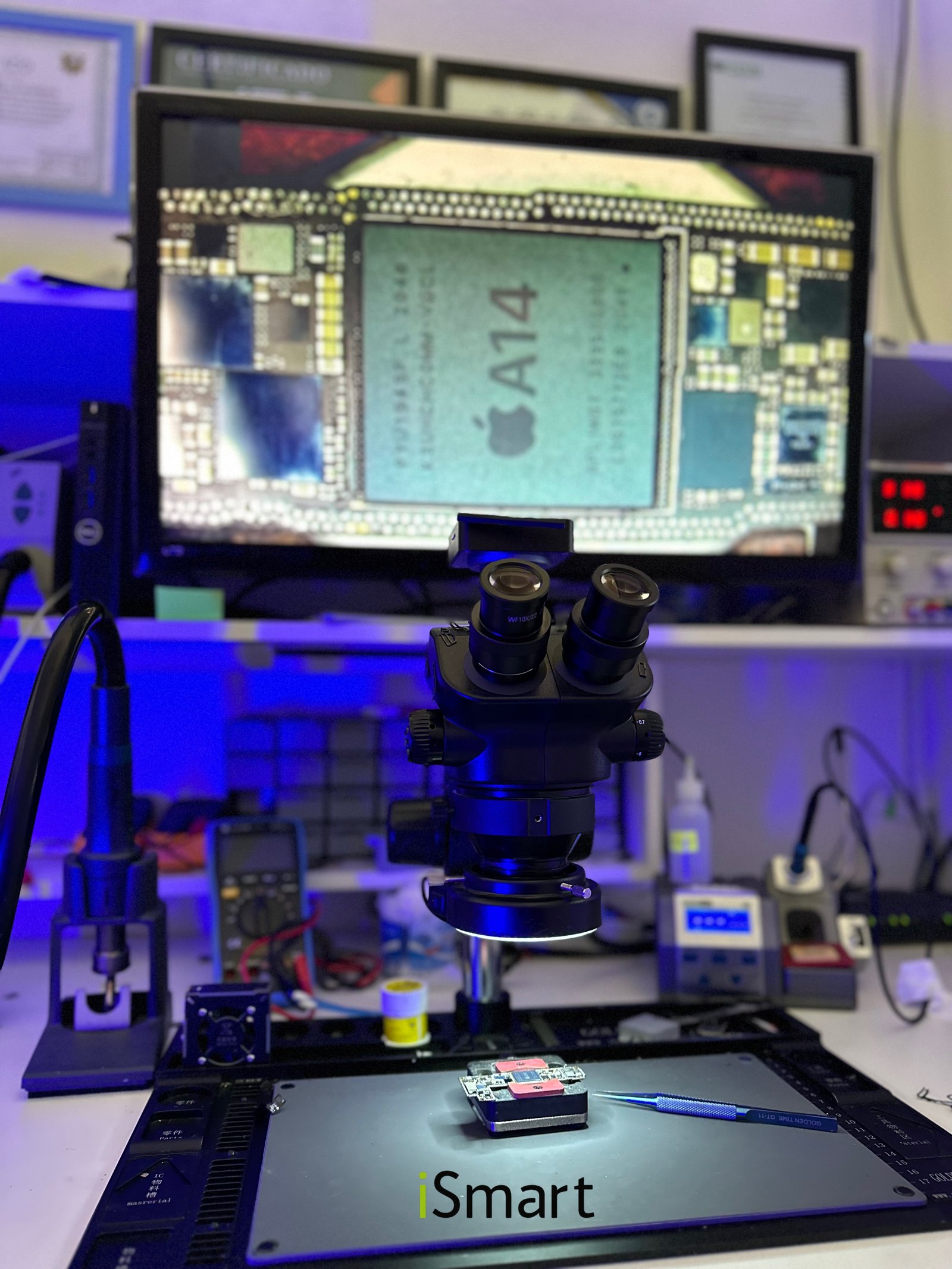 Estação de reparo da iSmart com microscópio e placa de iPhone em análise no laboratório próprio